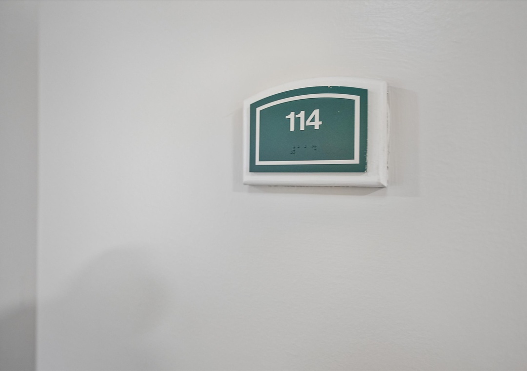 Room 114 awaits with accessible features including braille signage for guests with visual impairments.