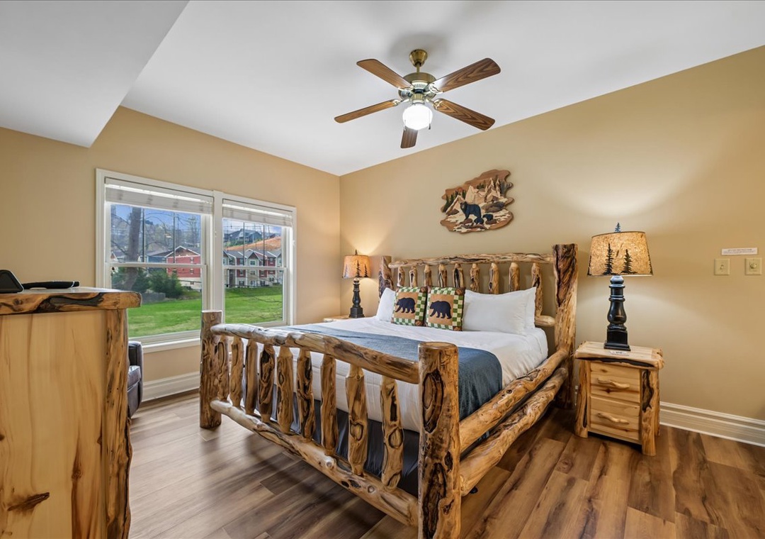 Your cozy retreat features rustic log furniture and warm mountain decor. Relax beneath the gentle ceiling fan while enjoying peaceful views.