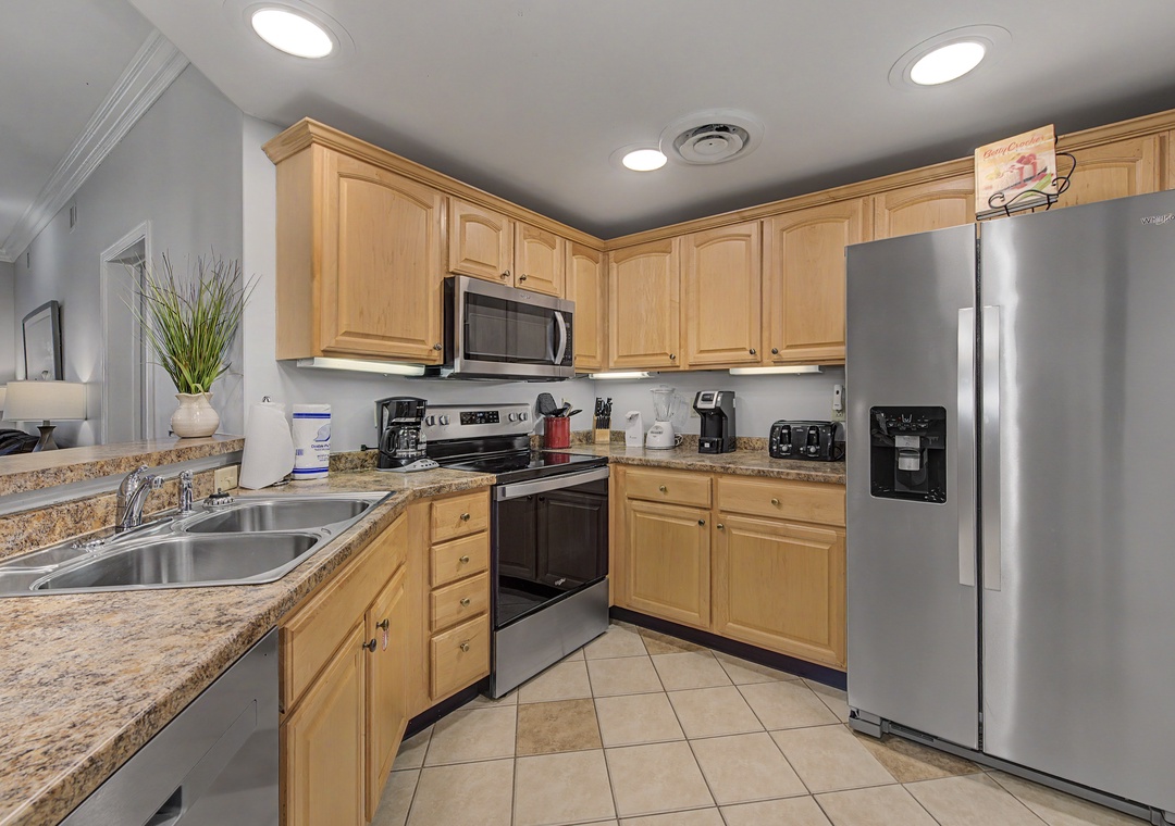 Your fully equipped kitchen features stainless steel appliances, granite countertops, and warm wood cabinetry perfect for preparing meals during your stay.