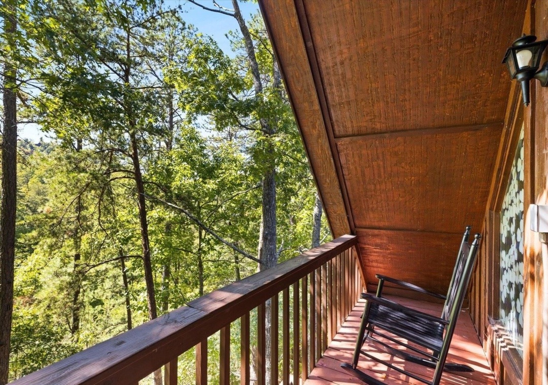 Settle into your private covered balcony with comfortable rocking chairs, where forest views and gentle breezes create the perfect retreat.