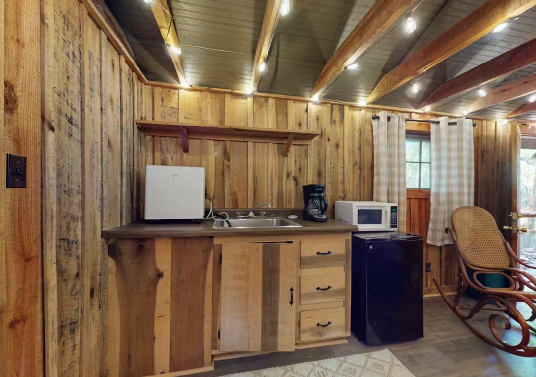 Your cozy rustic kitchen features handcrafted wood cabinetry, modern appliances, and exposed beam ceilings that create a perfect mountain retreat atmosphere.
