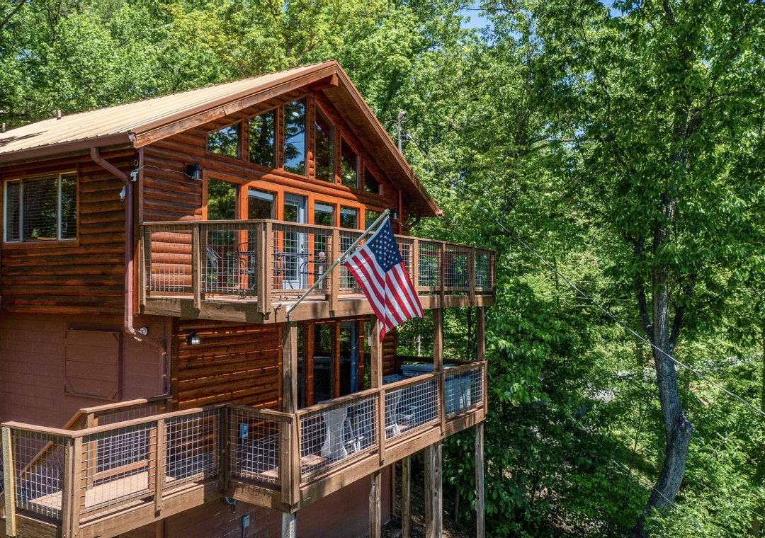 A charming log cabin nestled in a lush forest, with spacious wraparound decks perfect for morning coffee and soaking in the tranquil natural surroundings.