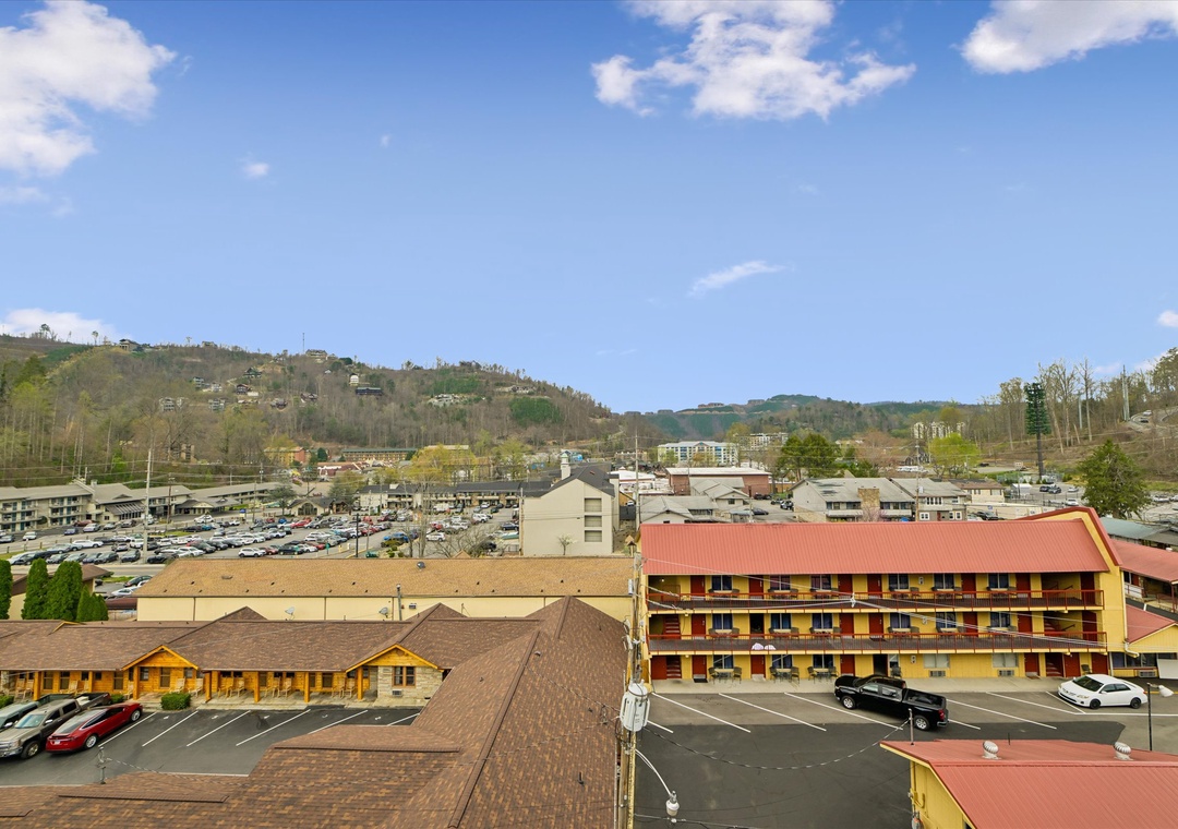 Elevated view of mountain town property with colorful buildings and surrounding hills creating a picturesque backdrop.