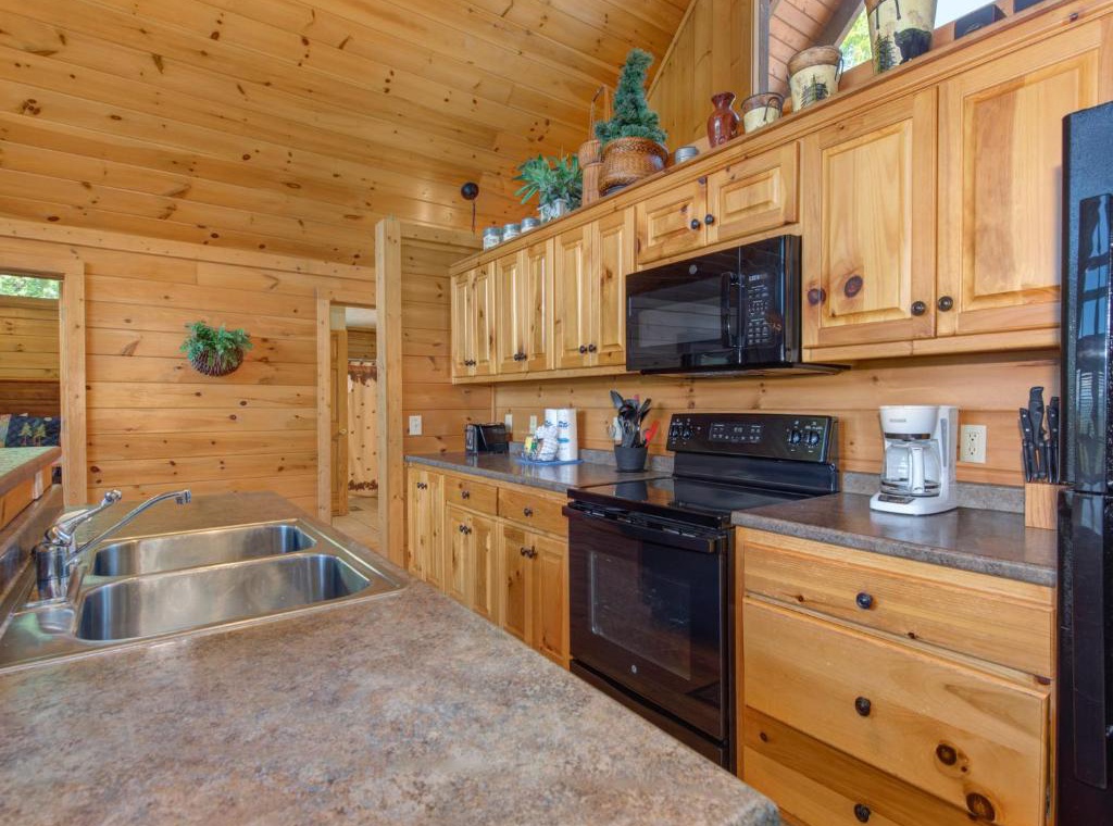Cook memorable meals in your rustic cabin kitchen, featuring warm pine cabinets and modern appliances for mountain getaway comfort.