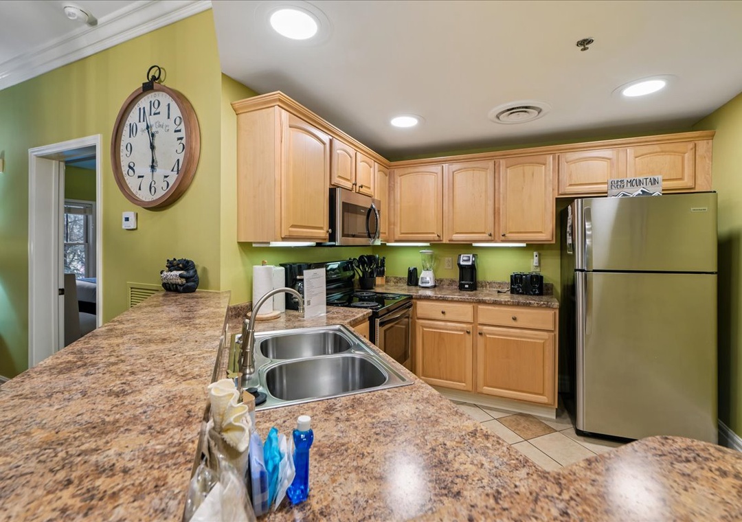 Your fully equipped kitchen awaits with granite countertops, stainless appliances, and vibrant green walls that energize morning coffee rituals.
