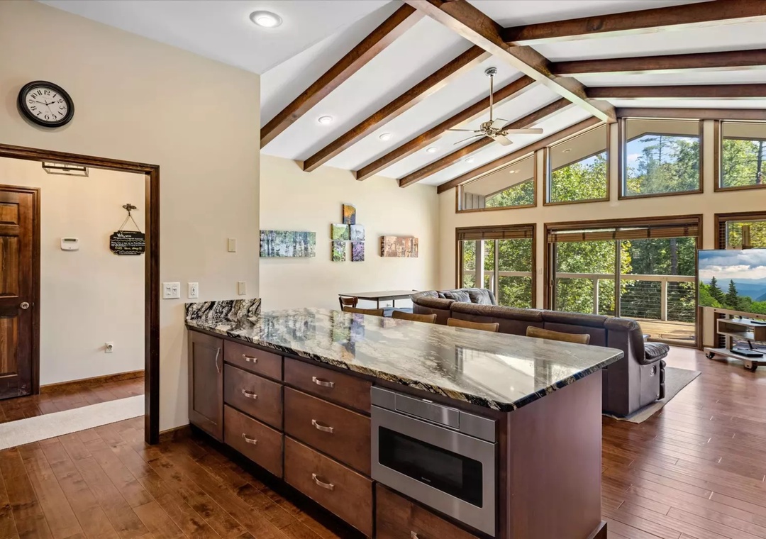 You'll love this open kitchen's granite island perfect for morning coffee while soaking in natural light from floor-to-ceiling windows.