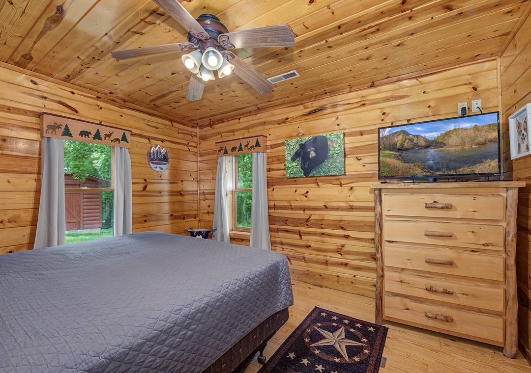 Drift off in your cozy cabin bedroom, wrapped in rustic pine and cooled by the ceiling fan, with forest views right outside your windows.