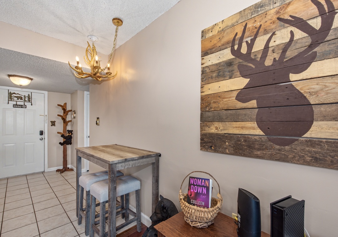 Step into your cozy retreat where rustic charm meets comfort—antler chandelier casting warm light over your own dining nook.