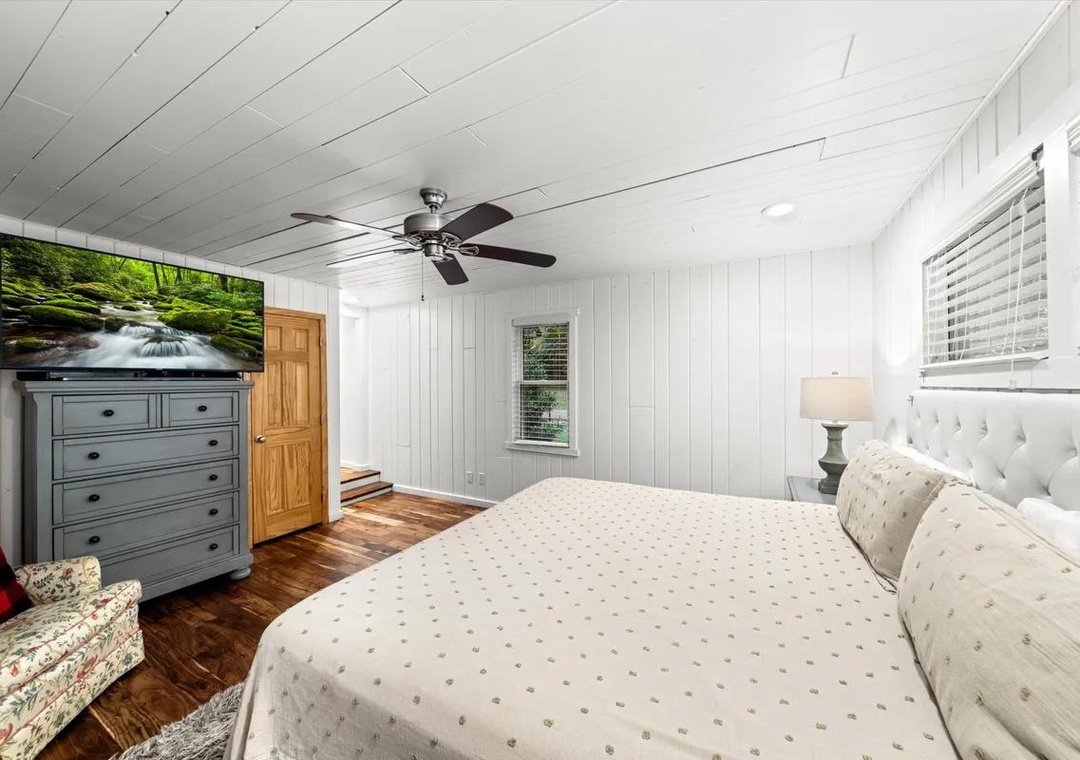 Relax in your peaceful bedroom with cozy bedding, warm wood floors, and charming cottage-style finishes that invite a restful night's sleep.