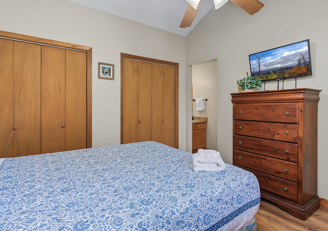 Your spacious bedroom features vaulted ceilings, warm wood accents, and generous closet space for all your belongings. The charming wood furnishings and soft linens create a peaceful sanctuary where you can truly unwind.