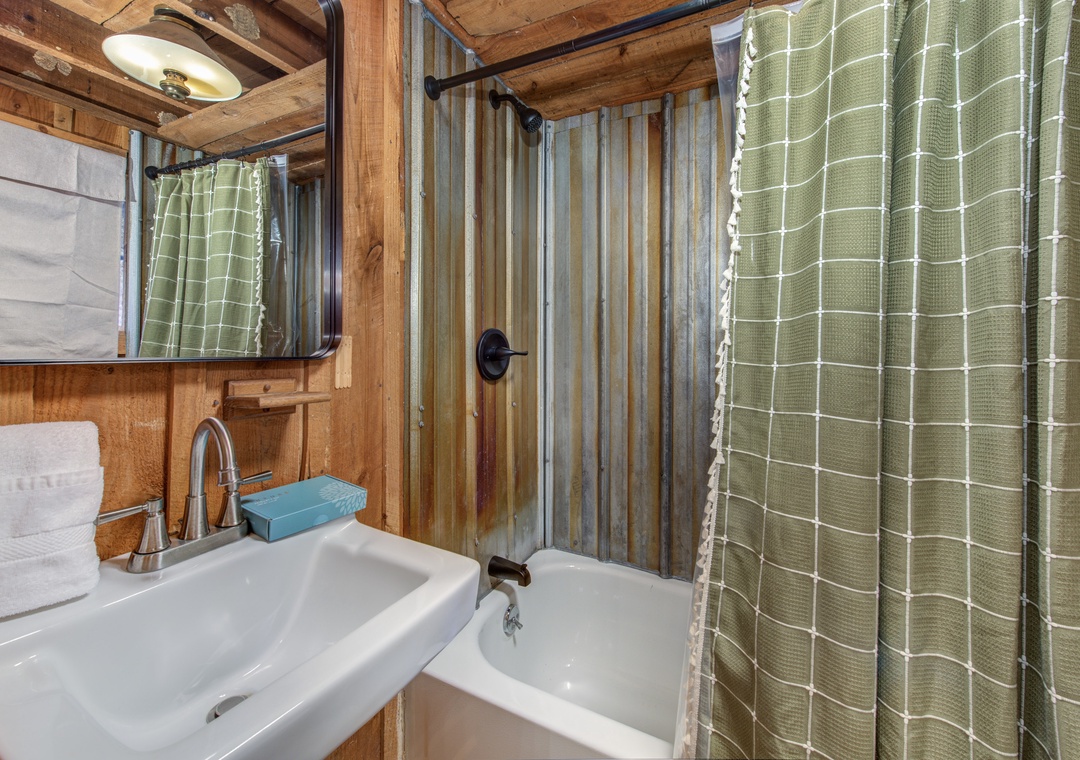 Unwind in your rustic bathroom featuring warm wood beams, a relaxing tub, and charming rustic details that create a cozy retreat.