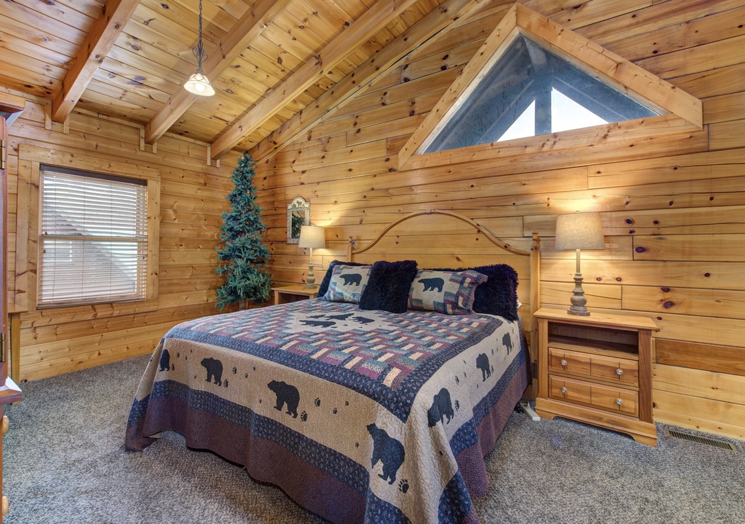 Rest peacefully in this cozy log bedroom with rustic charm, vaulted ceilings, and warm wood walls that create your perfect mountain retreat.