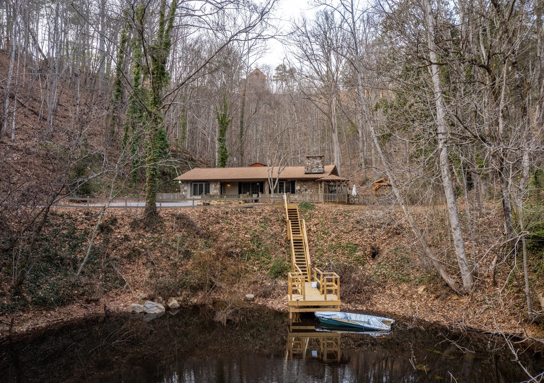 Secluded lakefront cabin nestled among bare winter trees with private dock and boat access for peaceful waterside getaways.