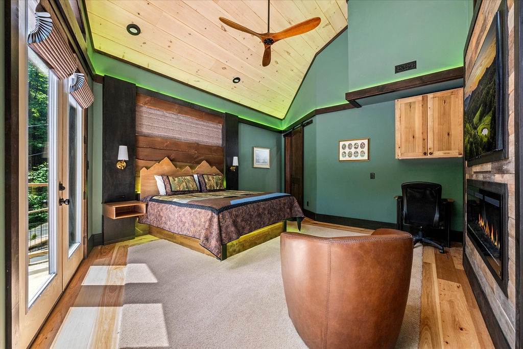 Sink into your plush bed under a soaring ceiling with warm wood beams, unwind by the cozy fireplace, and let nature inspire relaxation through your private balcony views.