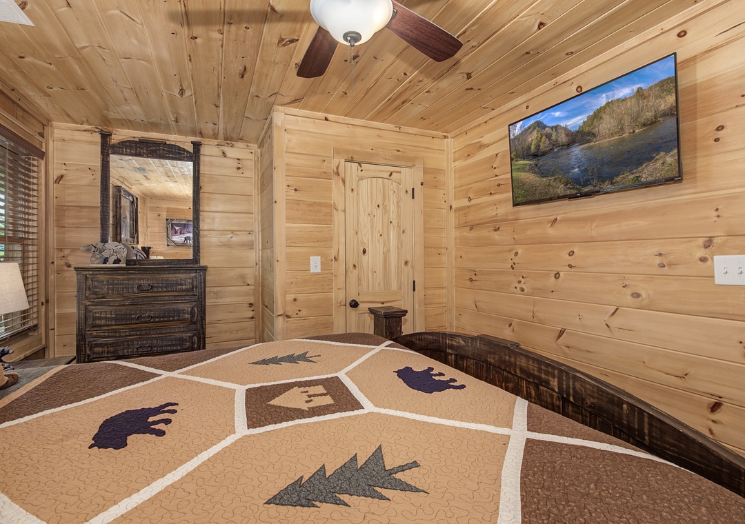 Cozy up in your rustic retreat with warm wood walls, a charming quilt, and mountain views on the TV. Your peaceful haven awaits.