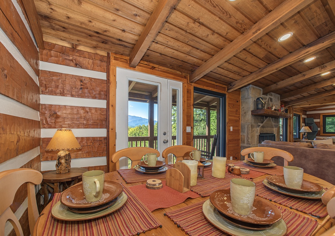Picture yourself sharing meals at this rustic dining table, where warm wood tones create an inviting mountain retreat. Through the door, stunning mountain vistas await your morning coffee or evening dinner.