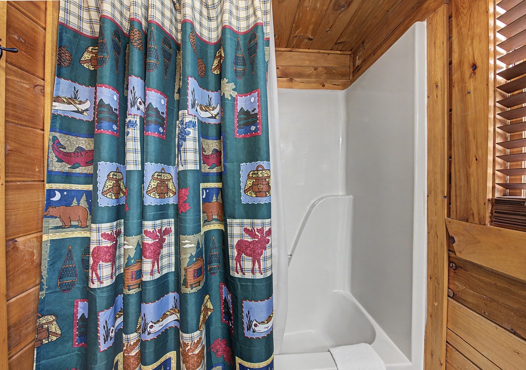 Your rustic bathroom features charming woodland-themed decor and a clean shower space, perfect for freshening up after mountain adventures.