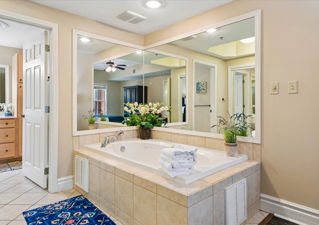 Unwind in your luxurious soaking tub with fresh towels and greenery creating a spa-like atmosphere for ultimate relaxation.