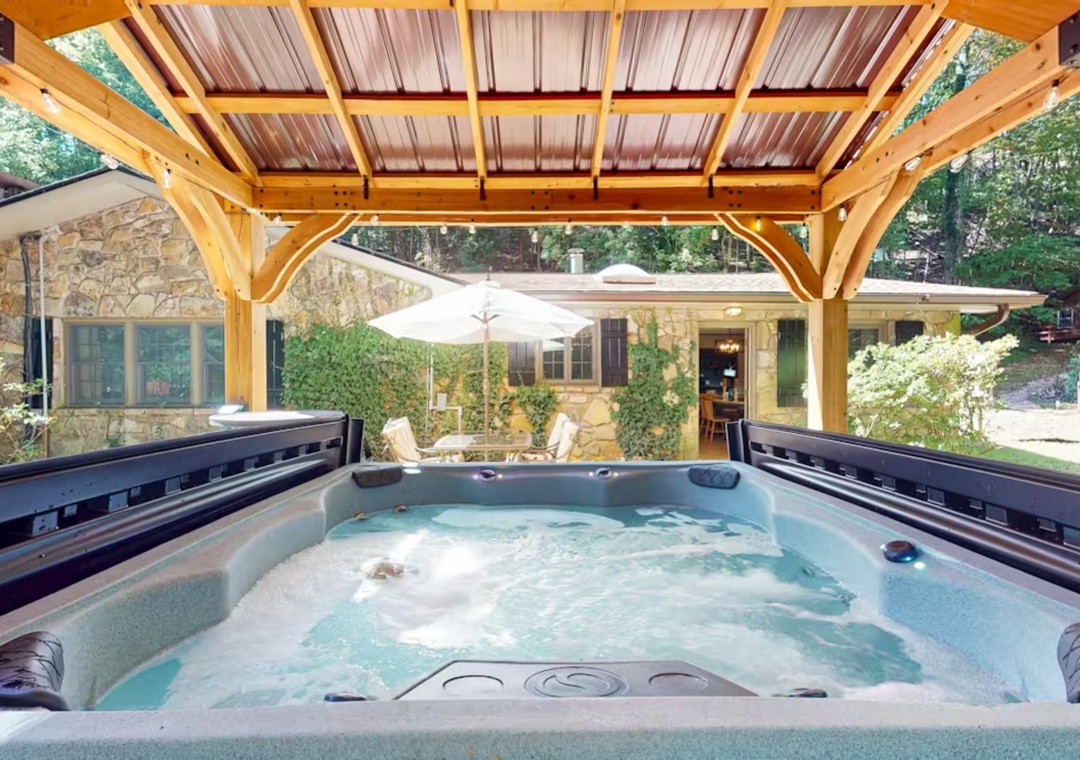 Soak your worries away in this private hot tub sanctuary, perfectly positioned under a rustic pergola with peaceful garden views surrounding you.