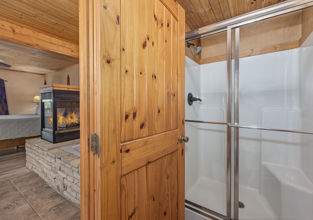 Warm wood accents and a see-through fireplace connect your private bathroom to the cozy bedroom beyond, making every moment feel like a retreat.