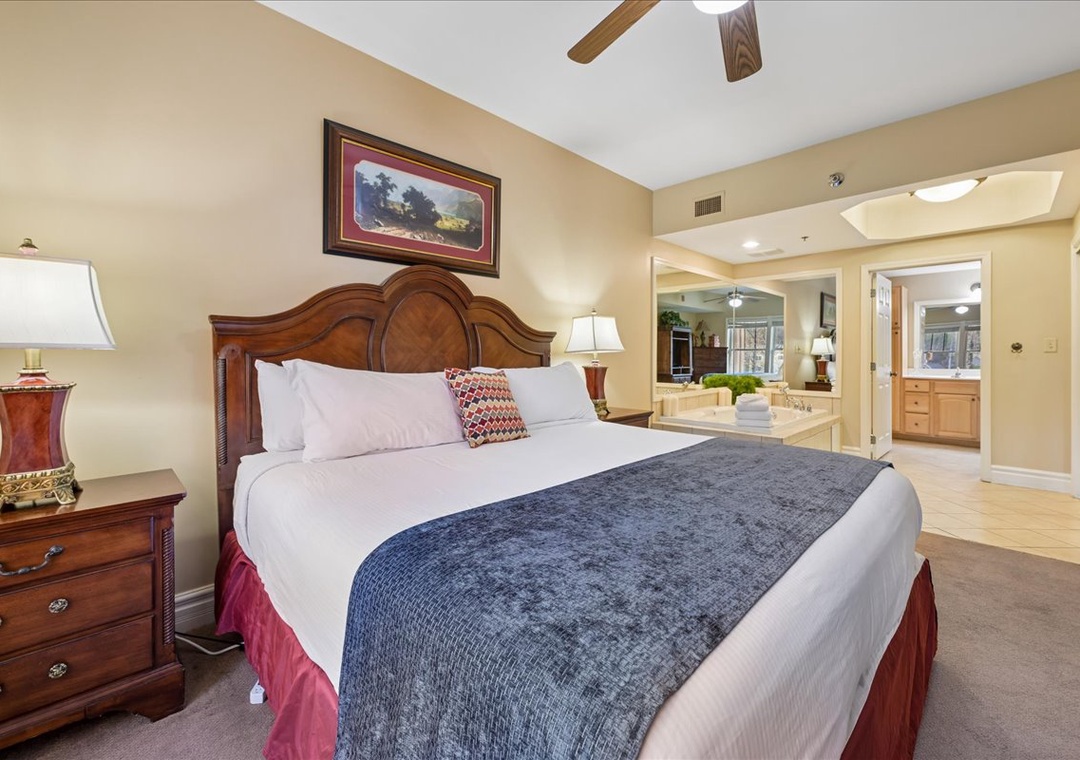 Unwind in your spacious bedroom featuring a luxurious king bed, warm wood accents, and an elegant open layout connecting to your private bathroom.