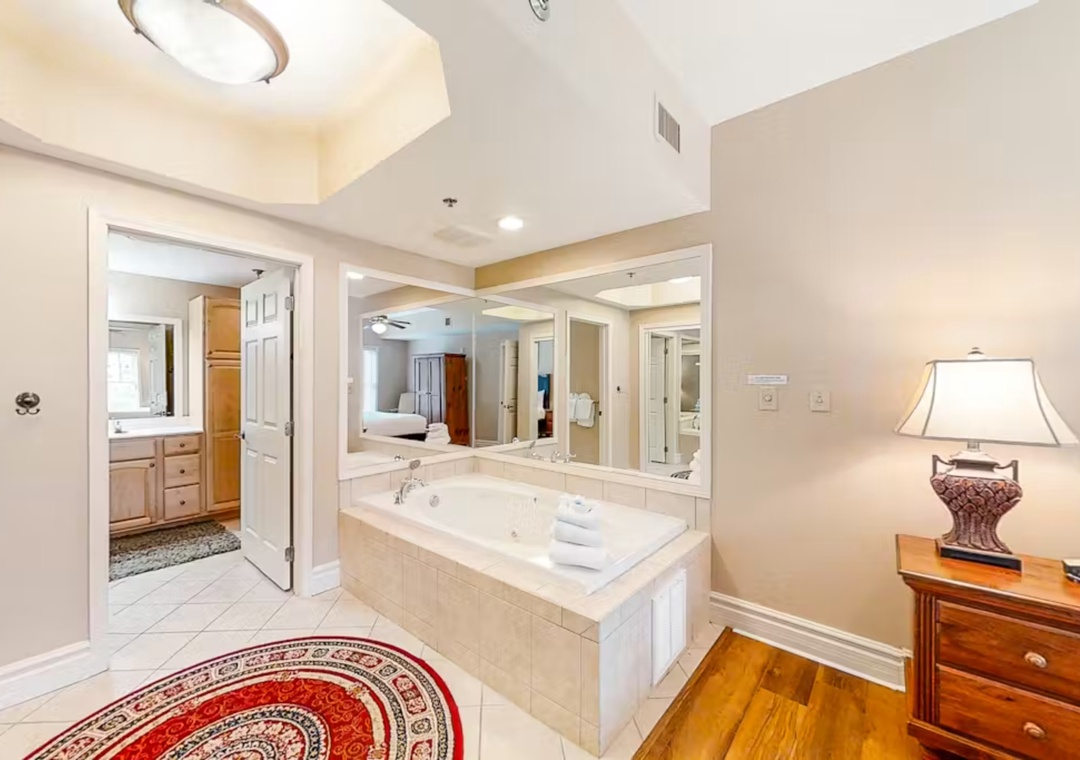 Unwind in your luxurious jetted tub surrounded by elegant mirrors and warm lighting, creating the perfect spa-like retreat.