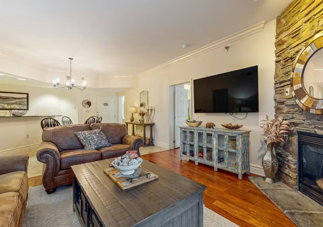 Unwind in this inviting living space featuring rich leather seating, rustic charm, and a cozy stone fireplace perfect for your evening relaxation.