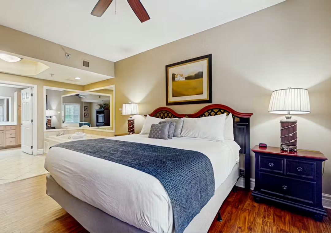 Sink into your plush king bed with elegant navy accents, while the spacious suite invites relaxation with warm wood floors and soft lighting.