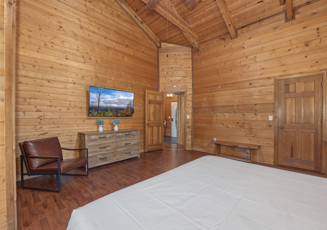 Step into your serene retreat with warm wood walls and soaring vaulted ceilings that create a cozy yet spacious feel. Unwind in the leather chair or rest on your plush bed after exploring the mountains.
