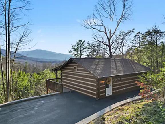 This charming mountain cabin offers privacy and stunning panoramic views, nestled among trees with ample parking and a peaceful setting for your getaway.