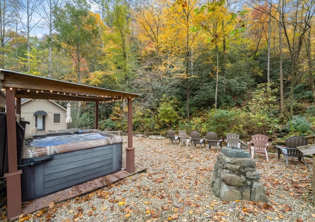 A secluded outdoor retreat nestled among vibrant autumn foliage, featuring a sheltered hot tub and gathering space surrounded by nature's seasonal display.