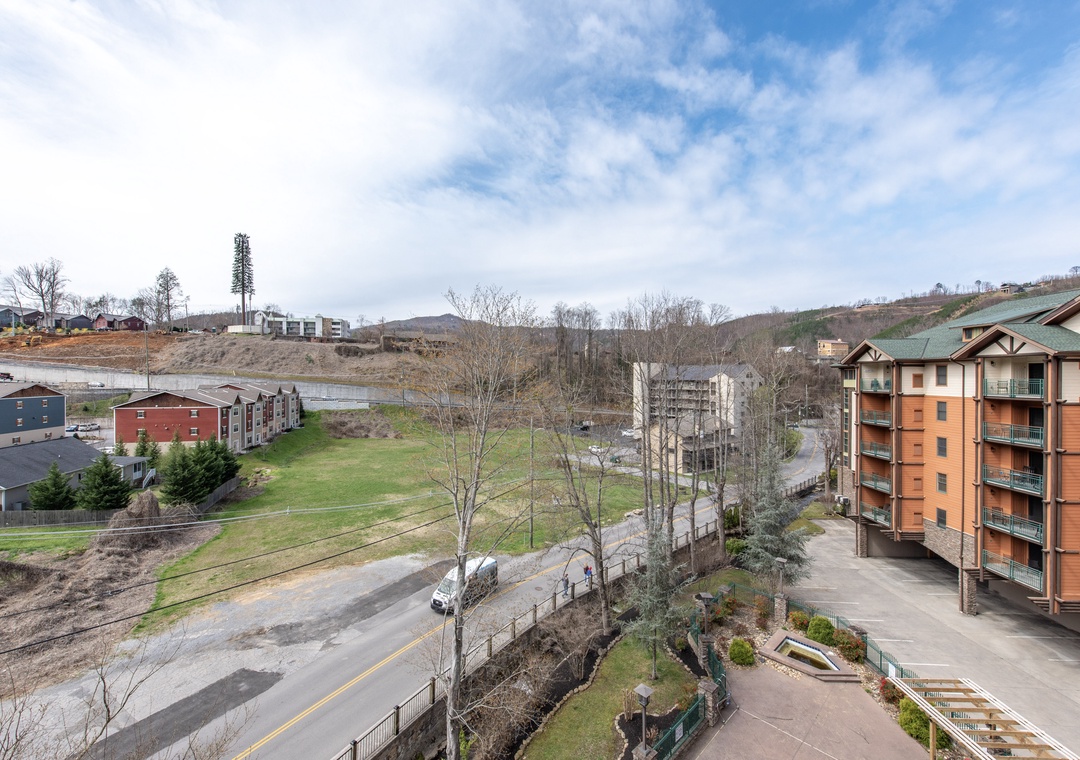 Scenic hillside community with modern apartment buildings and mountain backdrop near your vacation rental.