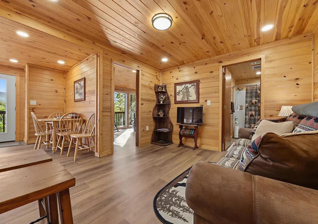 Step into the warmth of wood-paneled walls and vaulted ceilings, where rustic charm meets home comfort. Unwind on plush seating, gather at the dining table, or step onto your private balcony—your mountain retreat awaits.