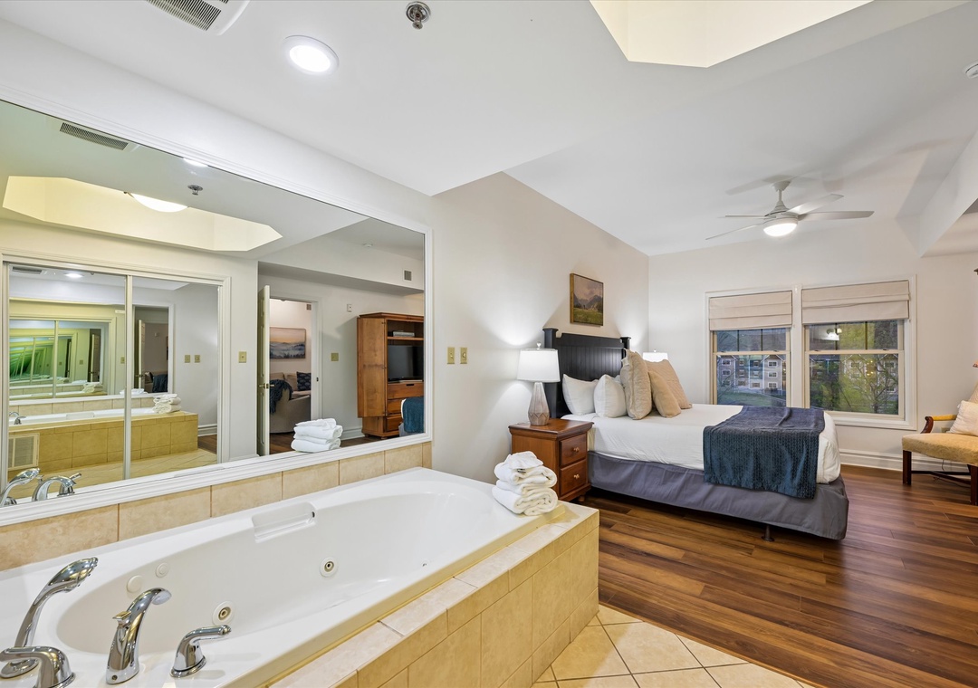 Unwind in your luxurious suite featuring a romantic jetted tub and king bed, where comfort meets elegance in every detail.