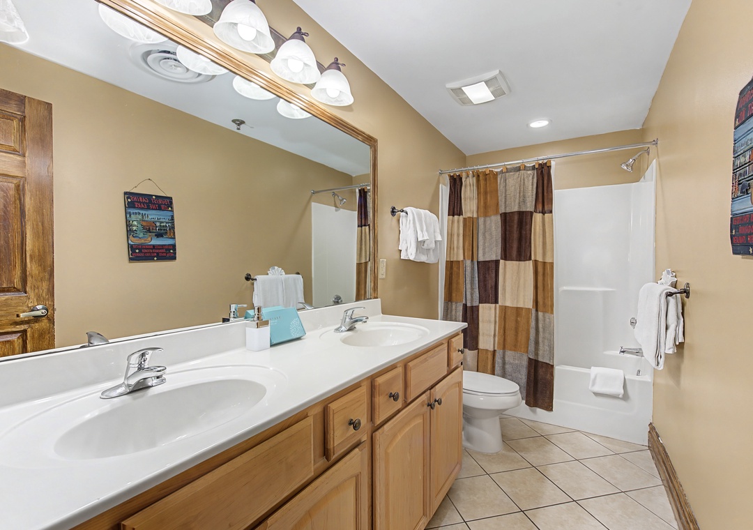 Refresh in your spacious bathroom with double vanities, warm lighting, and a relaxing shower-tub combo for unwinding after your adventures.
