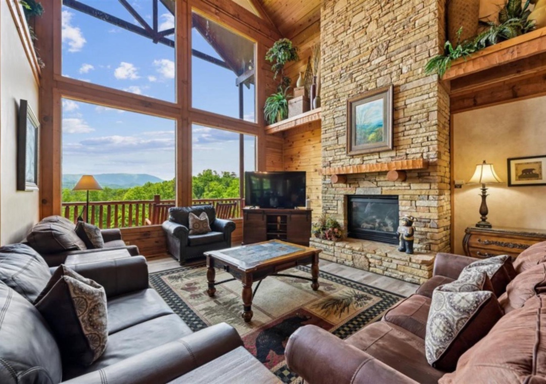 Relax in this stunning mountain retreat where soaring windows frame breathtaking valley views. Gather around the stone fireplace, sink into plush seating, and enjoy the perfect blend of rustic charm and modern comfort.