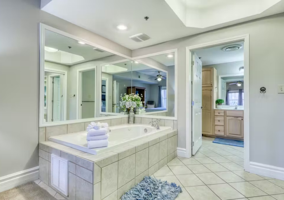 Unwind in your private spa-like bathroom with soaking tub, fresh towels, and elegant mirrors creating the perfect retreat.
