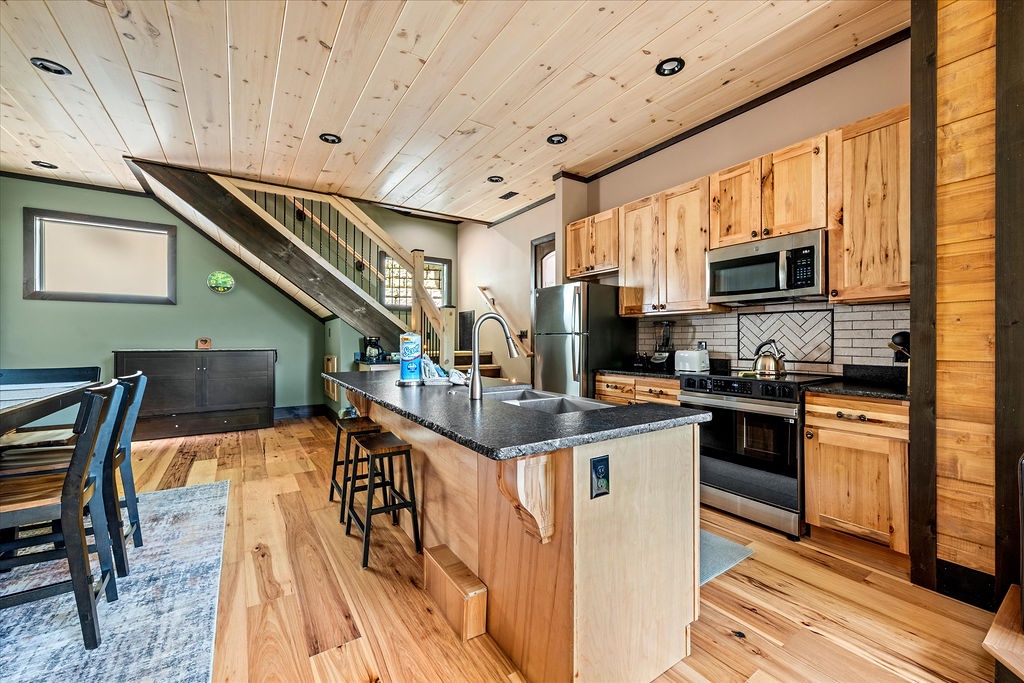 Step into your fully equipped kitchen where natural wood tones create a warm mountain retreat. The spacious island invites you to gather, cook, and create memories together.