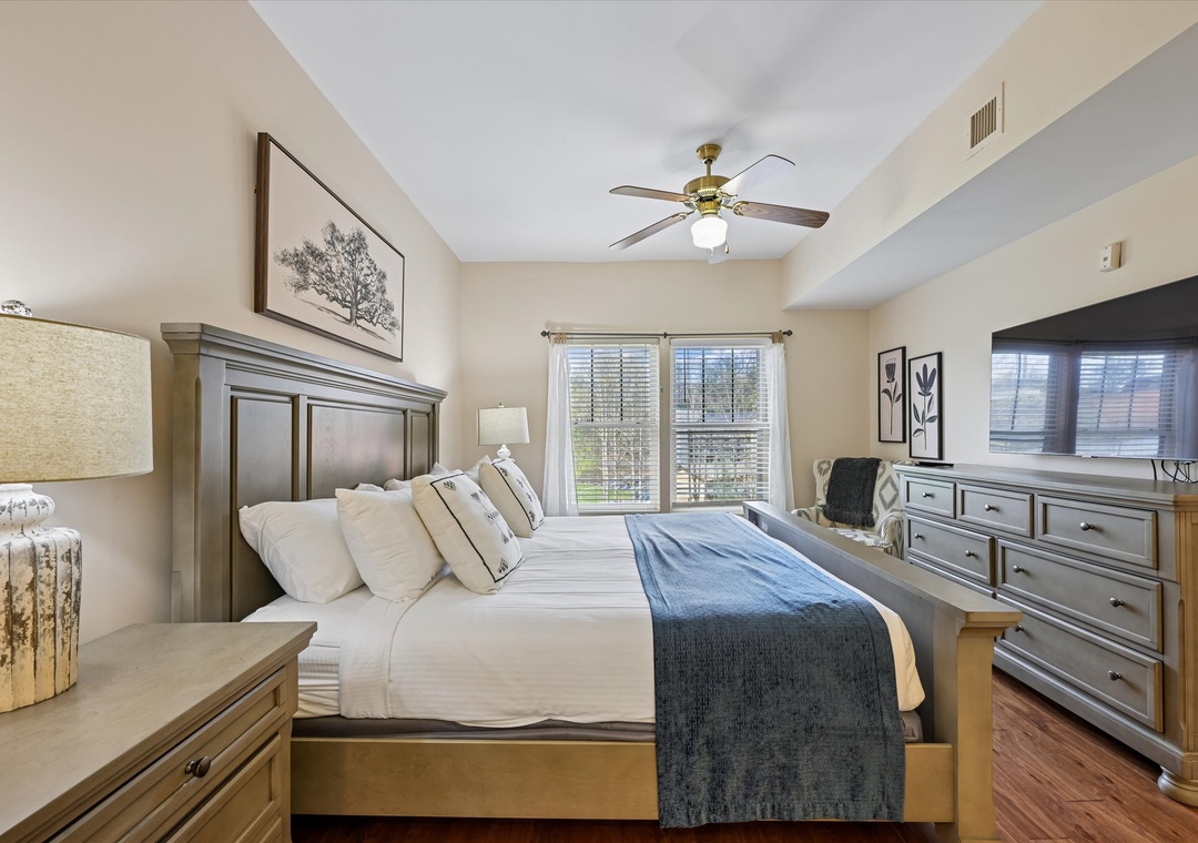 Unwind in this elegant bedroom featuring a plush king bed, soothing neutral tones, and modern amenities for your perfect retreat.
