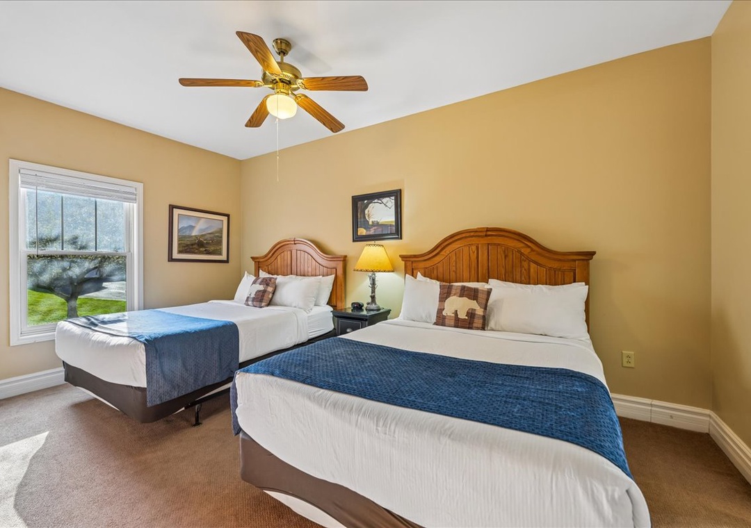 Unwind in your comfortable twin bedroom with crisp linens and cheerful natural light streaming through the window.