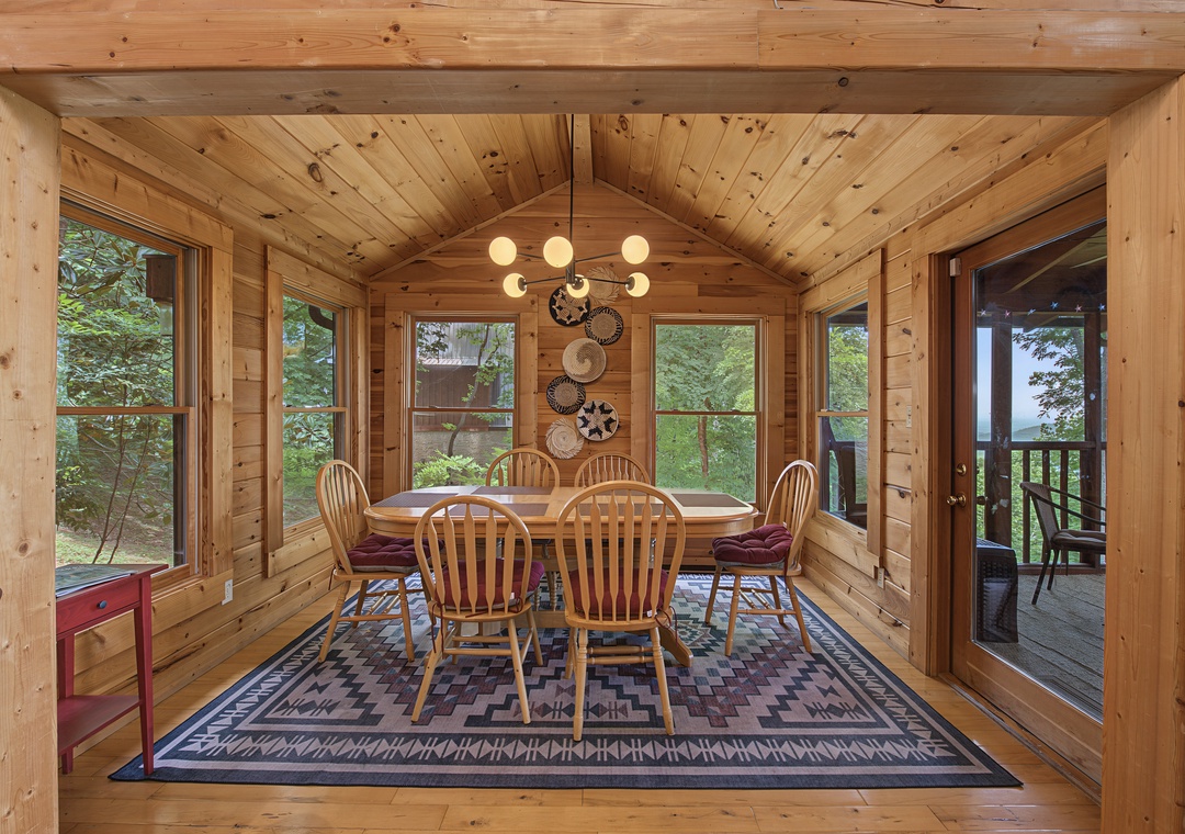 Gather around your dining table in this warm, wood-paneled room with cathedral ceilings. Light pours through picture windows, and doors open to your private deck overlooking peaceful greenery.