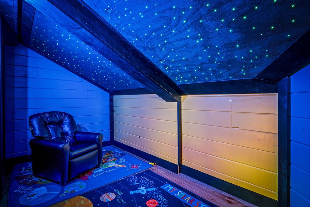 Unwind beneath a stunning starlit ceiling in this cozy lounge space, where plush seating and ambient lighting create your perfect retreat for movie nights or quiet reflection.