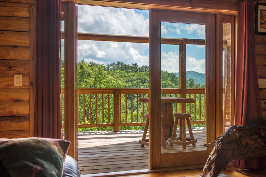 Step through your private door onto a sun-drenched balcony where rolling green mountains stretch endlessly before you, creating the perfect spot to sip morning coffee or watch clouds drift by.