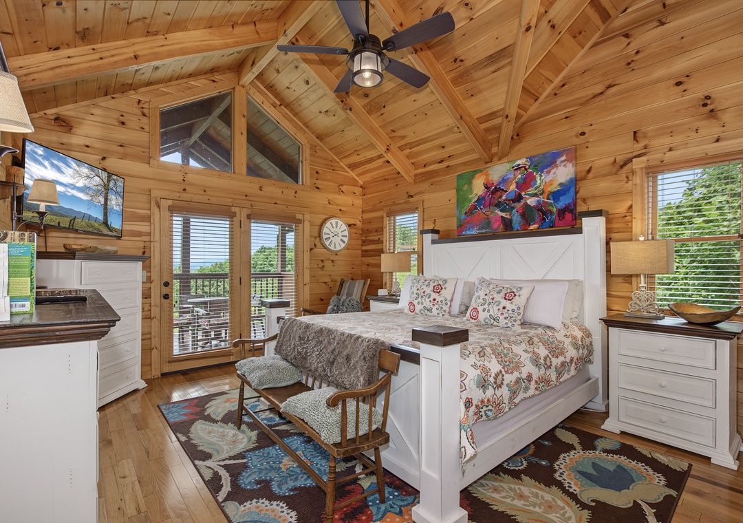 Step into your cozy cabin suite with vaulted wood ceilings, a plush king bed, and vibrant local art. French doors open to your private balcony with mountain views. Relax in the rocking chair or unwind with your favorite show.