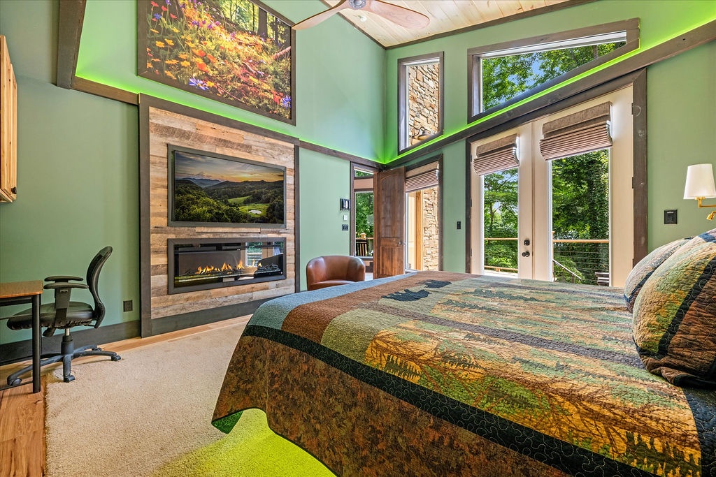 Drift off beneath soaring ceilings and natural light as your private fireplace flickers softly. Step through tall glass doors to your balcony, where lush mountain views await each morning.