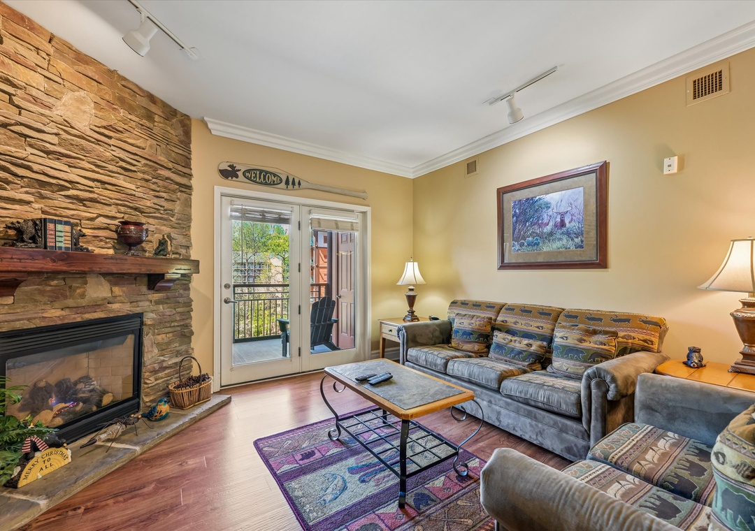 Cozy up in your spacious living room with stone fireplace and private balcony access, perfect for mountain evenings.