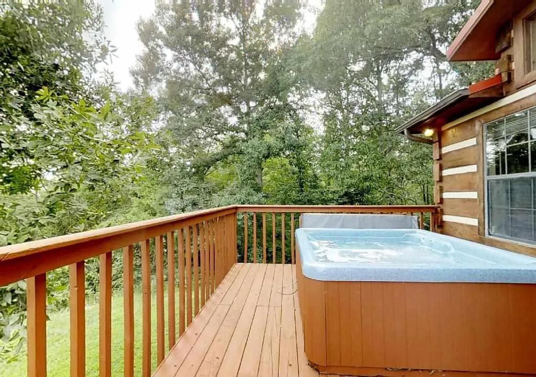 Step out onto your private deck with a bubbling hot tub surrounded by lush forest views—perfect for unwinding beneath the trees after a day of adventure.