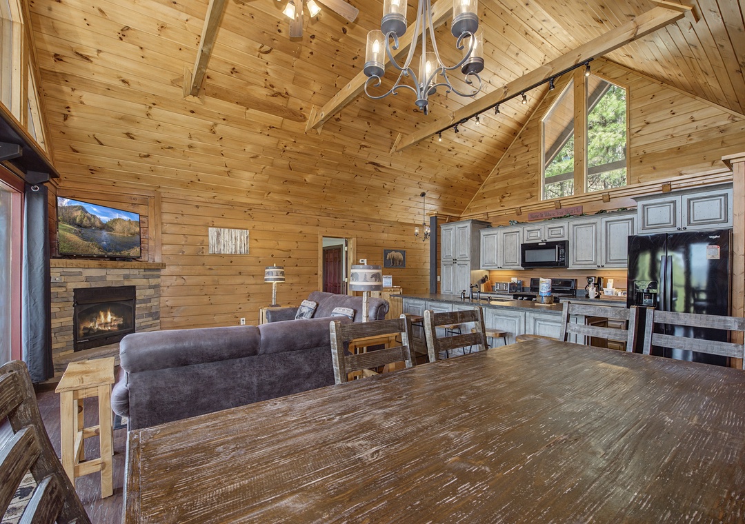 Gather around this expansive dining table where your group can share meals while enjoying the warmth of the fireplace and mountain views.