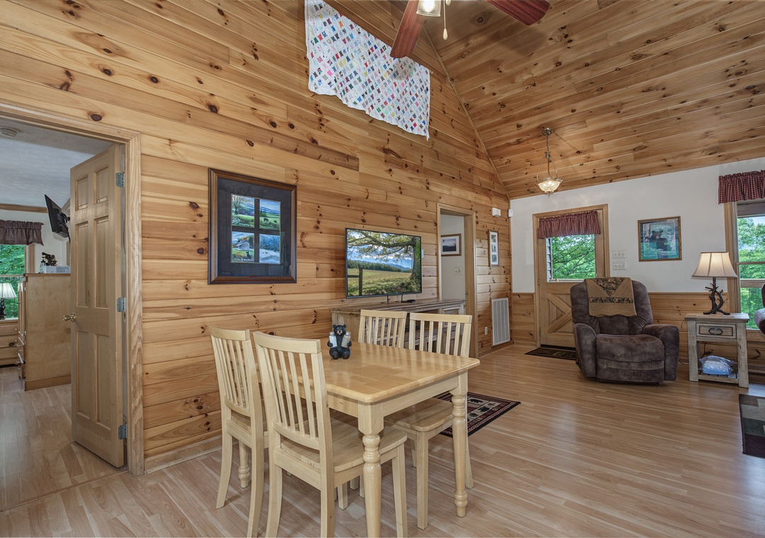 Step into your cozy cabin getaway with soaring cathedral ceilings of warm knotty pine, where rustic charm meets comfort in an open living space perfect for gathering together.
