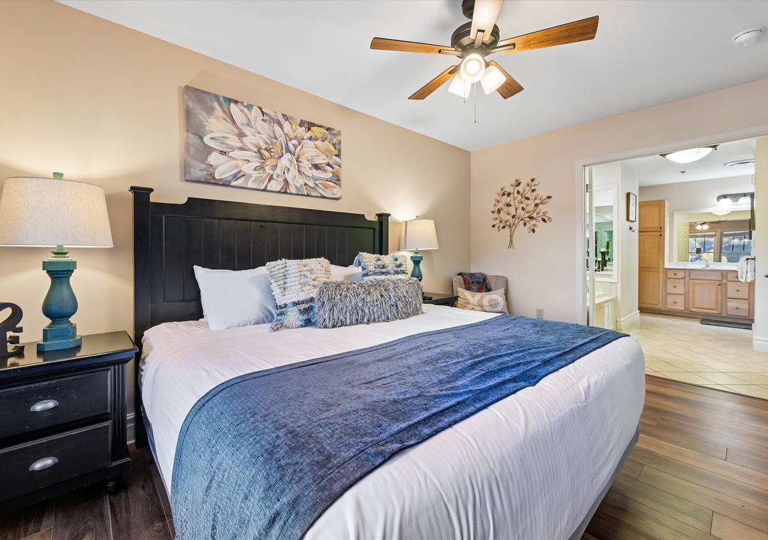 Sink into your comfortable king bed with crisp linens and plush pillows, where peaceful nights await under the gentle ceiling fan.